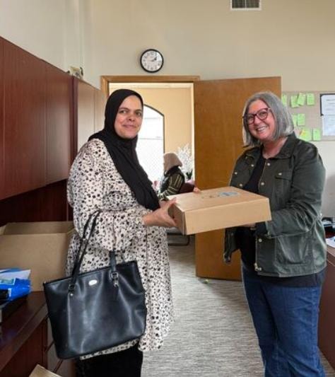ATE staff handing over a device to a community member